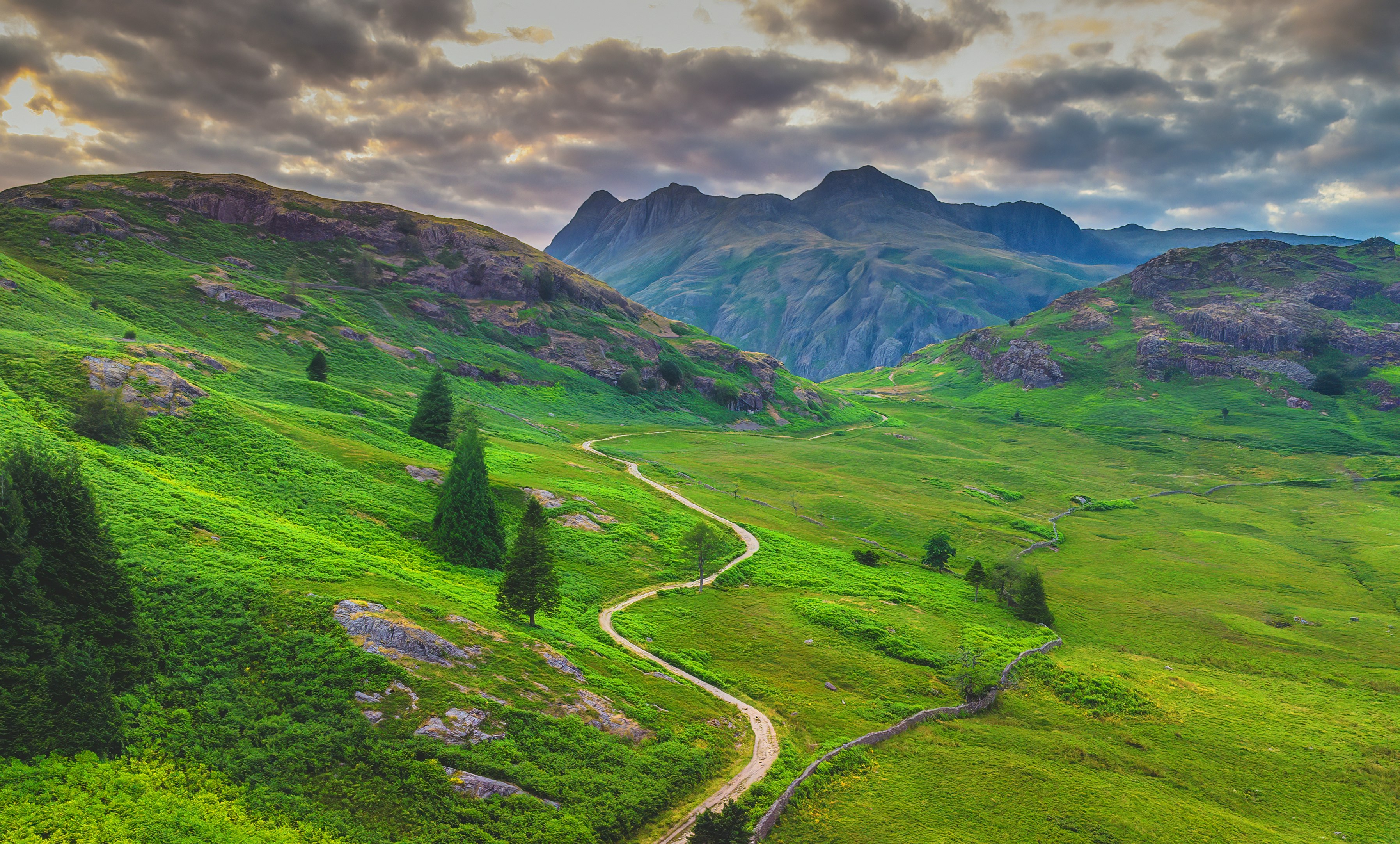 green grass field and mountain under white clouds and blue sky during daytime